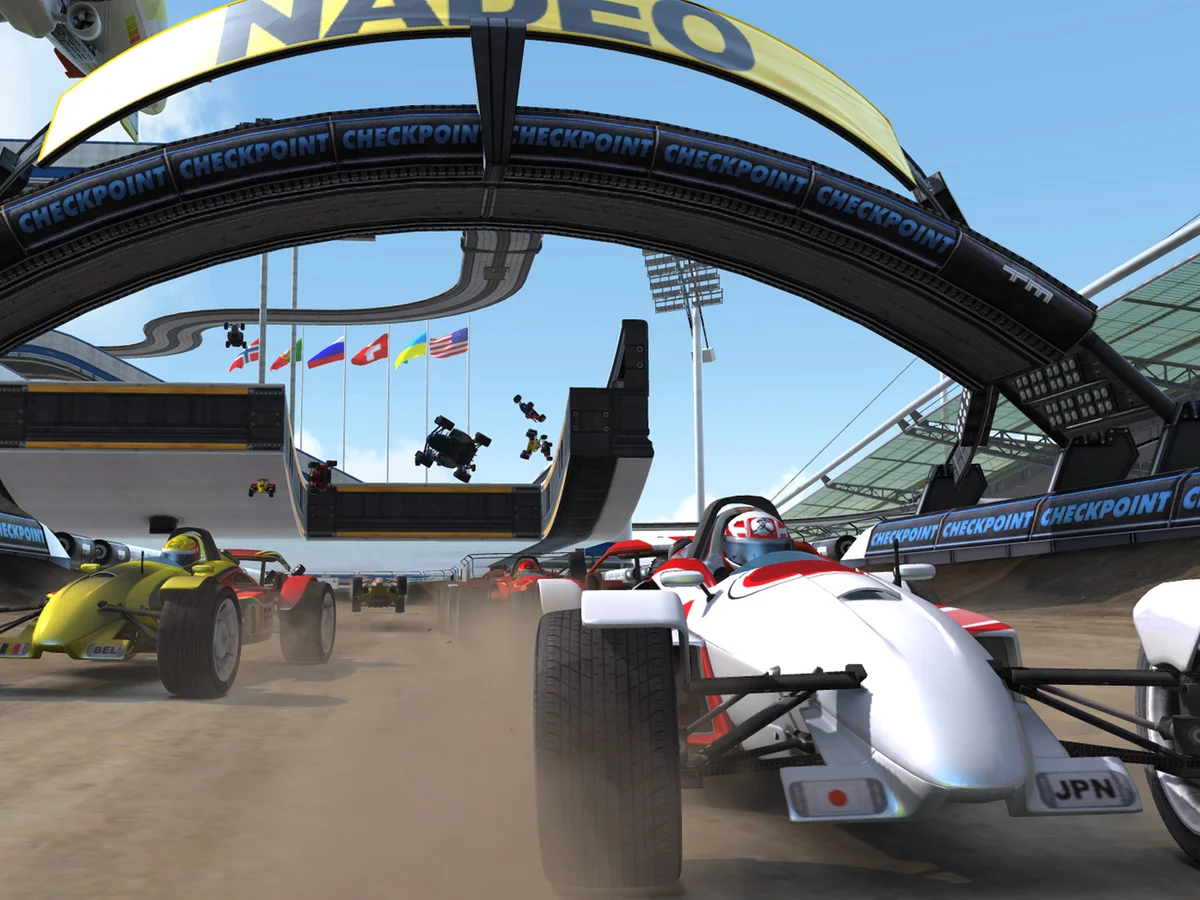 Monoposto colorate che passano sotto l'arco Checkpoint dello stadio in TrackMania Nations Forever